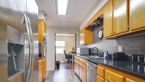 A kitchen with wooden cabinets, stainless steel appliances, and a tiled backsplash. - 4 Mi to Indian Rocks Beach: Quiet Family Escape! (Largo)