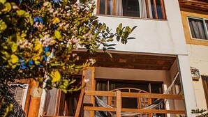 Ein zweistöckiges Gebäude mit einer Holztreppe, die zu einem Balkon führt.