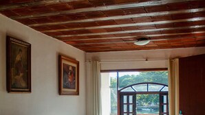 Ein Zimmer mit Bett, Schreibtisch, Stuhl und einem Fenster mit Blick auf Grünflächen.