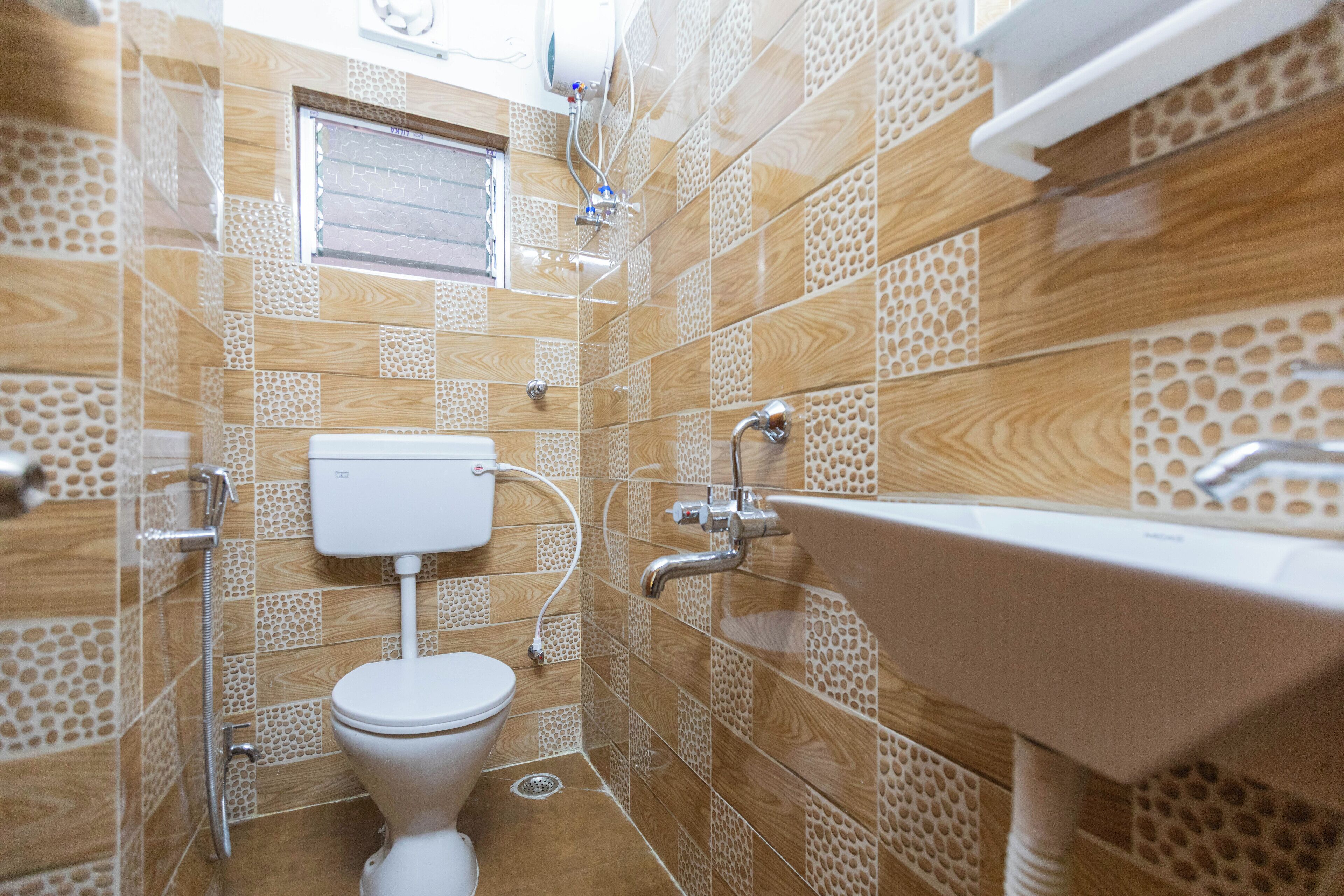 A bathroom with a toilet, sink, and shower.