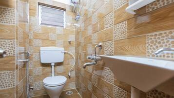 A bathroom with a toilet, sink, and shower.