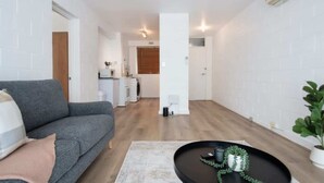 Un salon moderne avec un canapé gris, une table basse et une plante en pot.