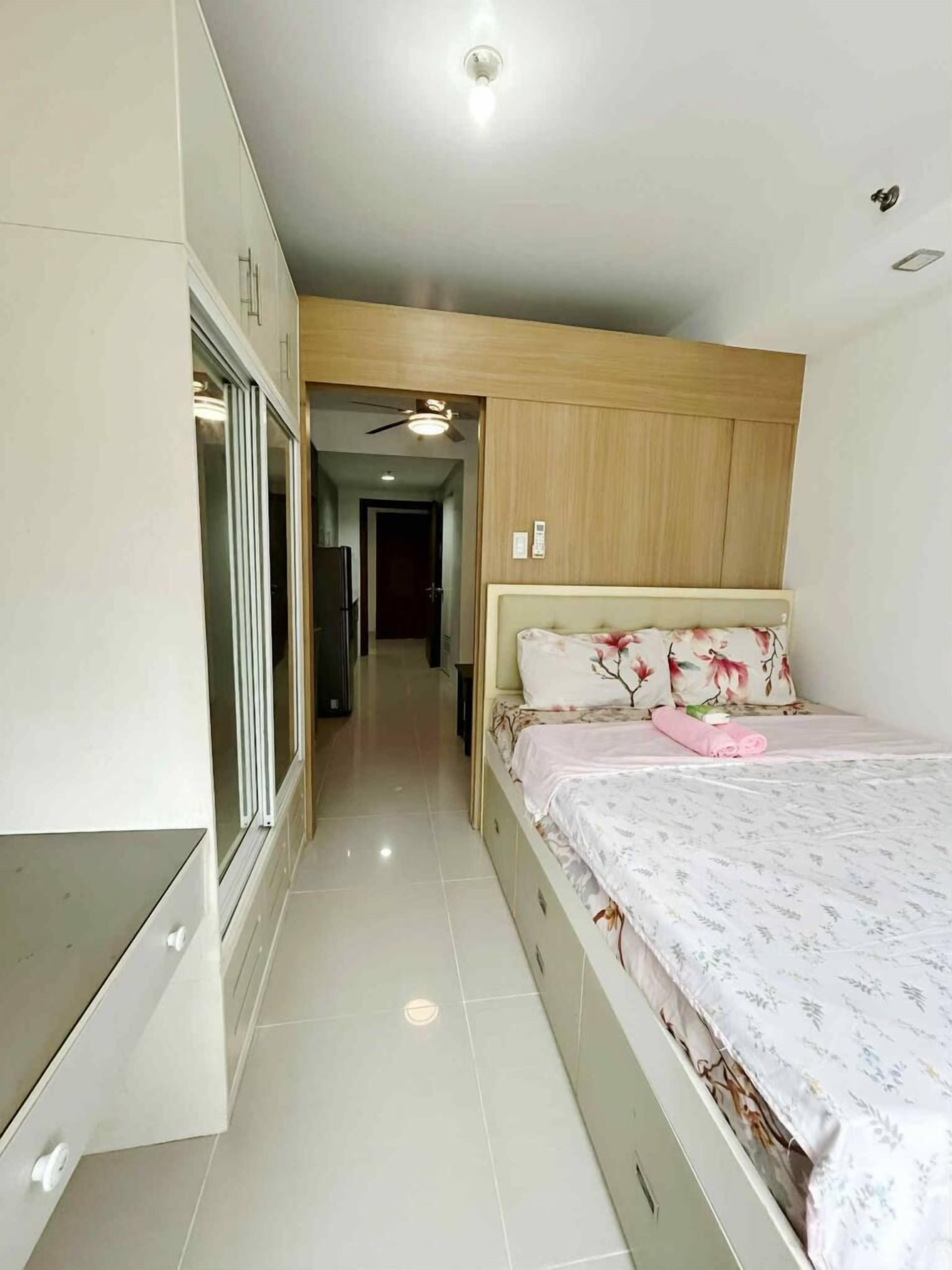 A bedroom with a bed, a wardrobe, and a ceiling fan.