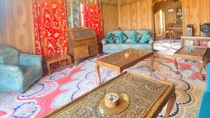 Una habitación tradicional con alfombras estampadas, muebles de madera y un techo decorativo.