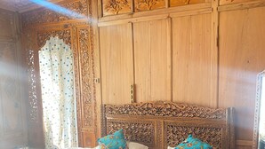 Un dormitorio con una cama grande, un elaborada cabecera de madera y un detallado panelado en la pared.
