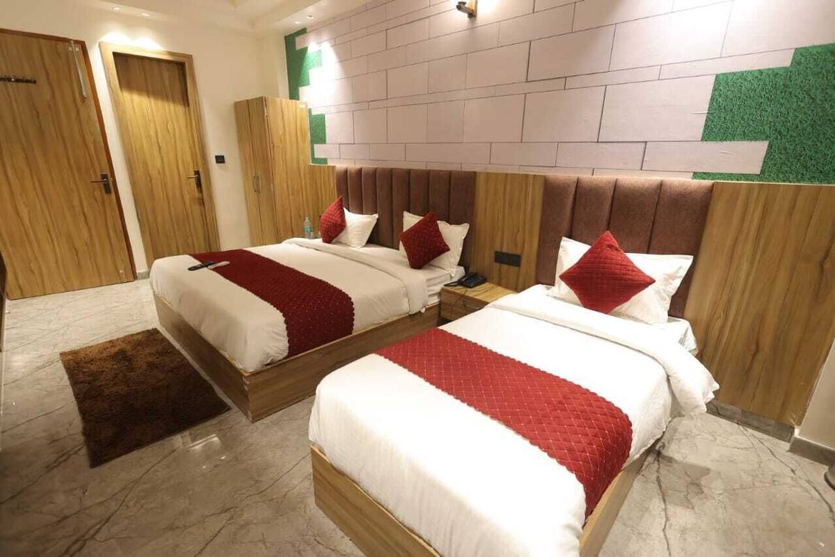 A hotel room with two beds, wooden headboards, and a marble floor.