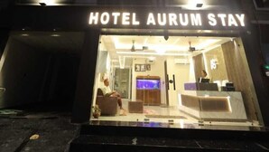 Entrada de hotel con un letrero que dice 'HOTEL AURUM STAY'.
