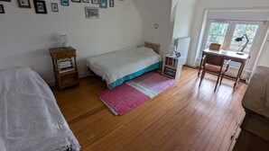 Una camera da letto con un letto, una scrivania, una sedia, un comodino e una finestra.