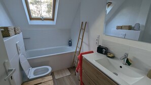 Un bagno con vasca, water e lavandino.