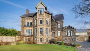 A large stone building with multiple windows and a well-maintained lawn. - Loughrigg at Lipwood House (Windermere)