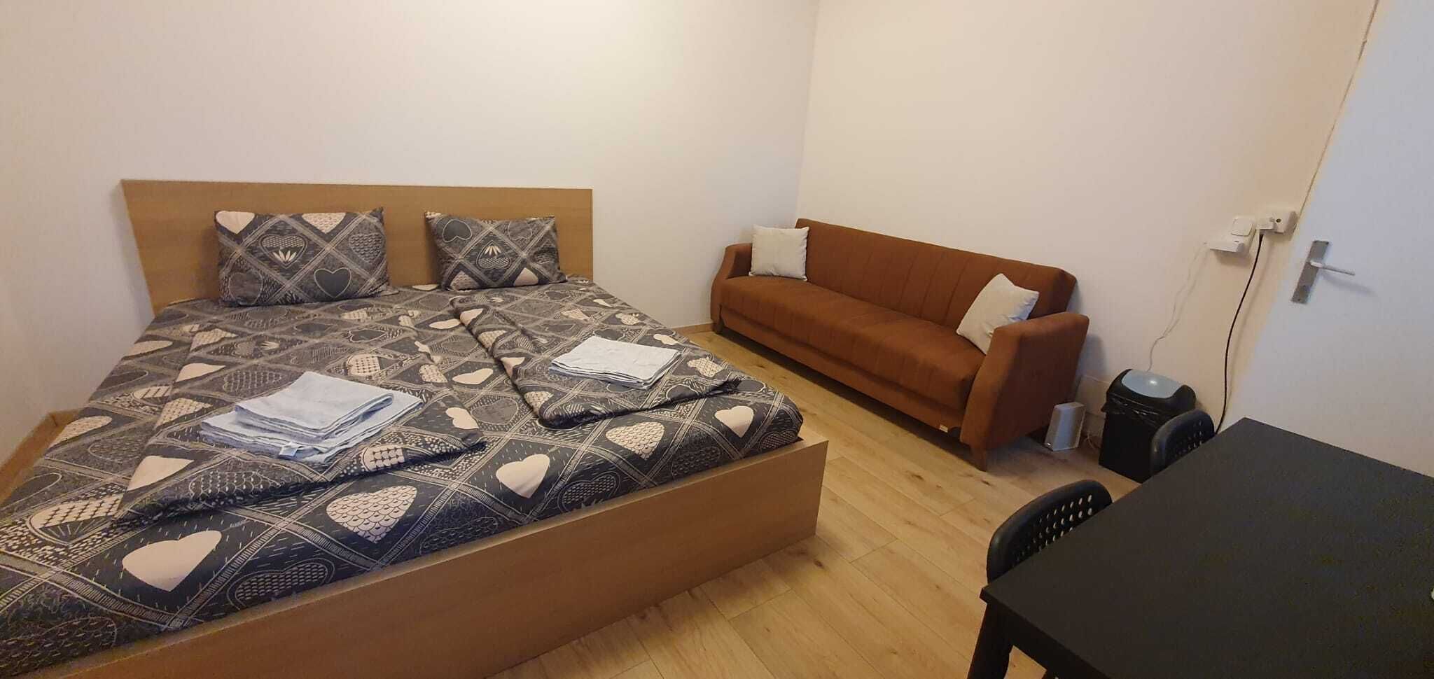Quarto com uma cama, um sofá, uma escrivaninha e uma cadeira.