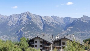 A mountain cabin with a balcony, surrounded by trees and mountains. - Nendaz, chalet 6 pers - Terrasse - Parking privé (Nendaz)