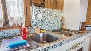 A kitchen with a sink, stove, and various utensils. - Nendaz, chalet 6 pers - Terrasse - Parking privé (Nendaz)