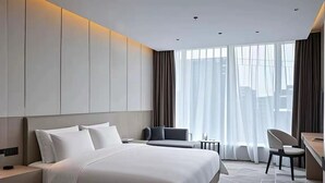 A modern hotel room with a large bed, a desk, and a chair. - Paco Hotel Guangzhou Baiyun Airport Liantang Metro (Guangzhou)