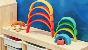 A wooden shelf with colorful rainbow-shaped objects and a toy giraffe. - Mugang Retreat｜Liuqiu Kids' Playroom (Liuqiu)