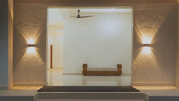 Una escalera que conduce a una habitación con un ventilador de techo, un banco e iluminación en la pared.