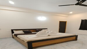 Un dormitorio moderno con una cama, un ventilador de techo y una puerta.