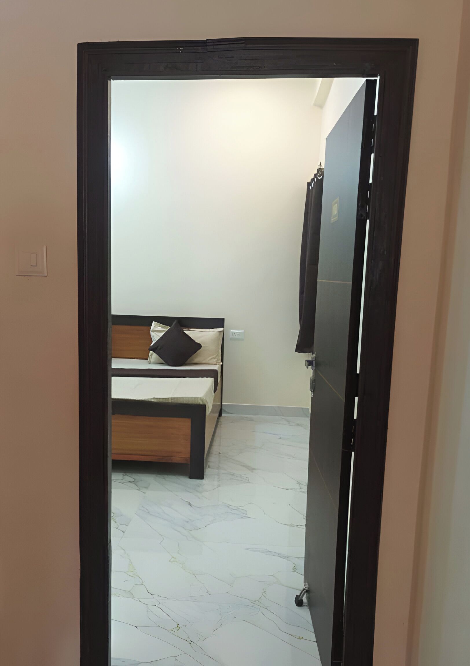 A room with a bed, a wardrobe, and a marble floor.