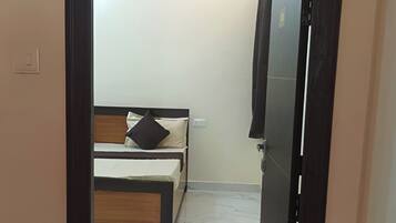 A room with a bed, a wardrobe, and a marble floor.