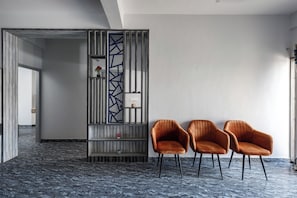 A modern room with a marble floor, a decorative wall panel, and two leather chairs. - Indigo Studio by Jadecaps 1bhk New Town Kolkata (Barasat)