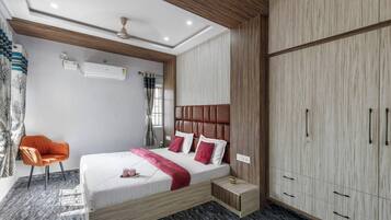 A modern bedroom with a bed, a chair, a wardrobe, and a ceiling fan.