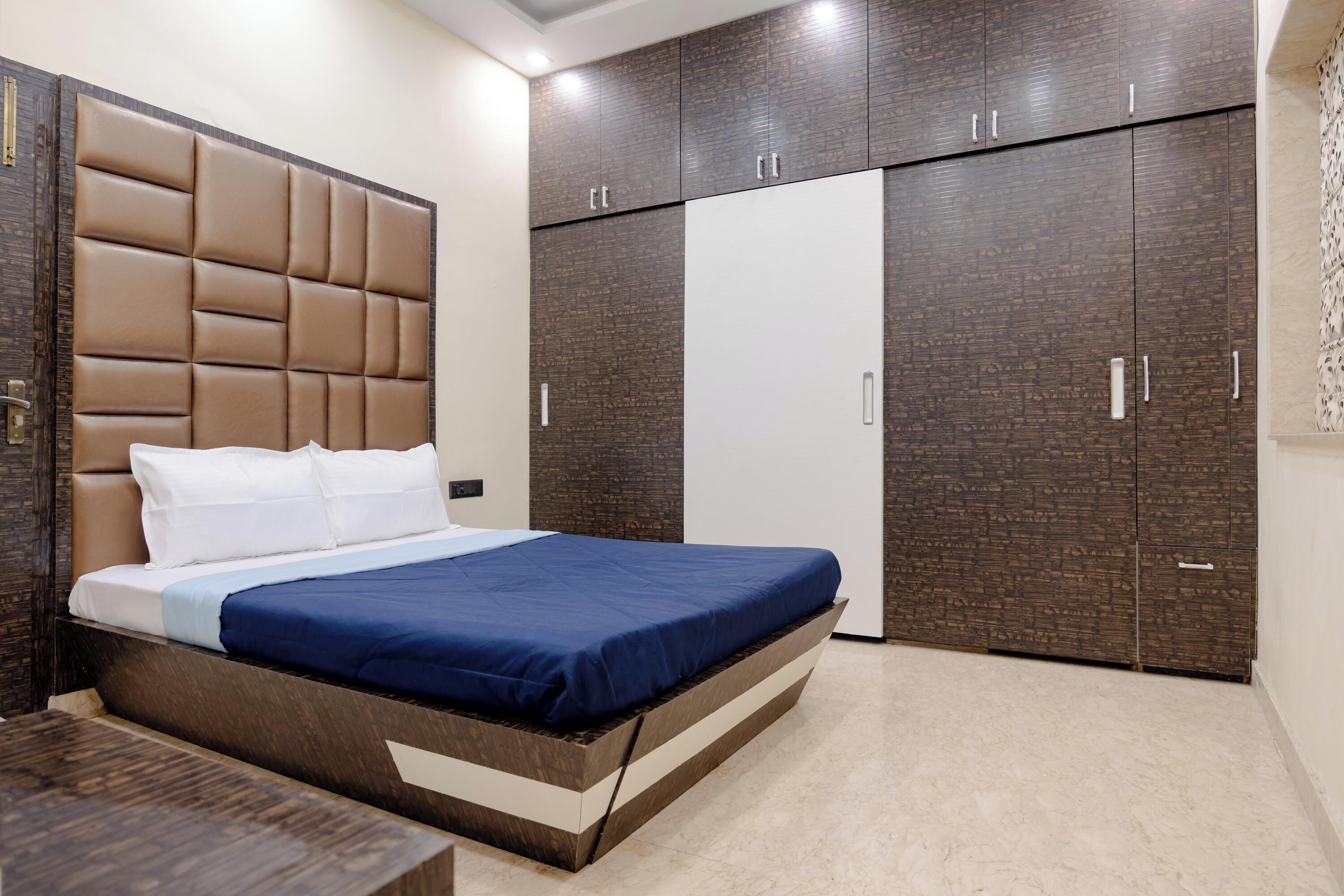 A bedroom with a bed, a wardrobe, and a nightstand.