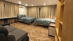 Une chambre d’hôtel avec deux lits, un bureau, une chaise et une armoire.
