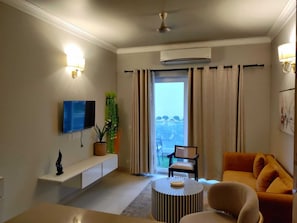 Luxury Apartment | Living area | 32-inch flat-screen TV with cable channels - Central Park Flower Valley (Gurugram)