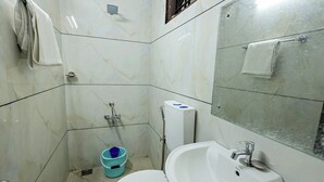 A bathroom with a white sink, a toilet, and a shower. - Landmark INN (Kasaragod)