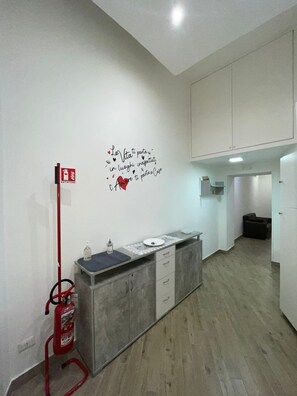 A modern kitchen with a built-in island, a fire extinguisher, and a wall decal. - The accommodation Dormire a Napoli Centro Holiday House Casa Vacanza, which is located in Naples (Napoli)