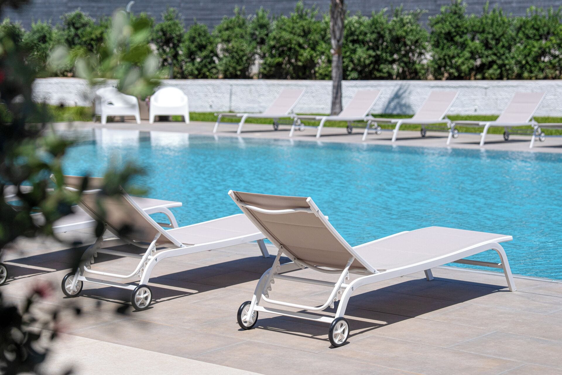 Un espace aménagé au bord de la piscine, avec des chaises longues et une piscine à l’eau d’un bleu limpide.