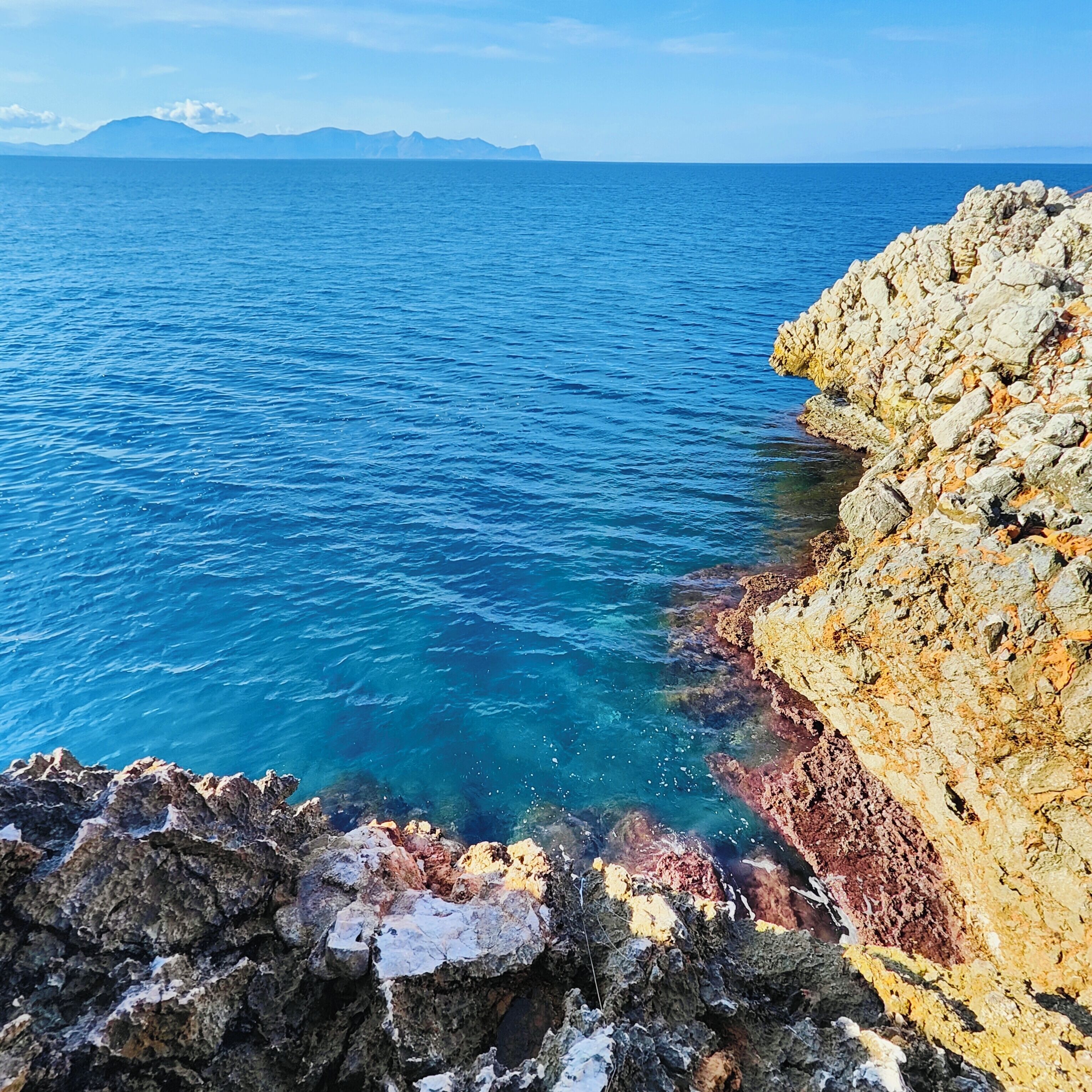 Un paisaje costero con aguas azules cristalinas y acantilados rocosos.