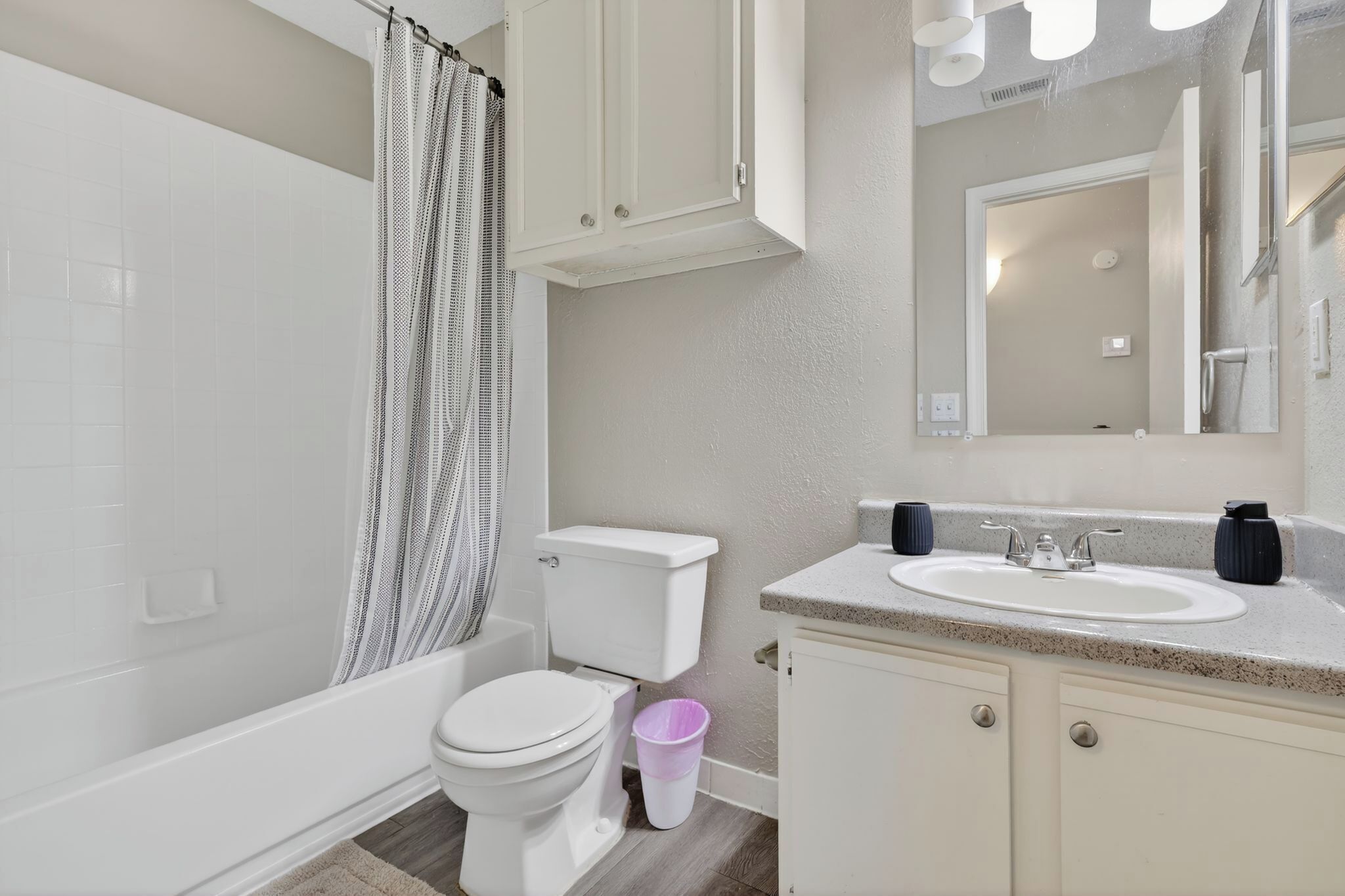 A bathroom with a toilet, sink, and shower.
