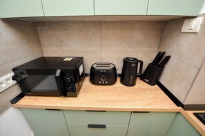 Eine Küche mit Mikrowelle, Toaster, Kaffeemaschine und Messern auf der Arbeitsfläche.