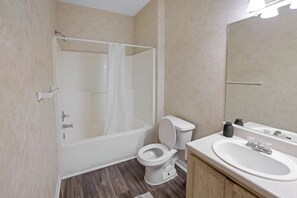 A bathroom with a bathtub, toilet, and sink. - Cozy Retreat w/ Balcony & Modern Comforts (Birmingham)