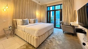 Een moderne hotelkamer met een groot bed, een bureau, een stoel en een televisie.