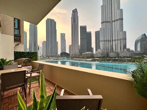 Un balcón con vista a un horizonte urbano y una piscina.