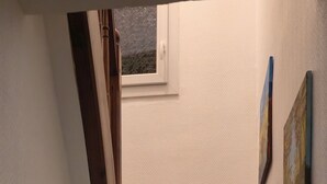 A wooden staircase with a handrail, leading to a landing with a window and two paintings on the wall. - House with a garden in Le Havre, quiet location, near the tram, sleeps 2 to 6 people.  (Le Havre)