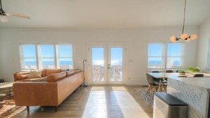 Amplia sala de estar con sofá, comedor con mesa y sillas, y encimera de cocina.