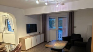 A modern living room with a glass dining table, a sofa, and a television. - Villa nikki, ideal base in croatia, 5o meters from the lake (Bilice)