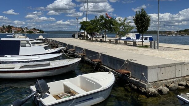 A marina with several boats docked at a concrete pier, a clear sky, and a calm body of water. - Villa nikki, ideal base in croatia, 5o meters from the lake (Bilice)
