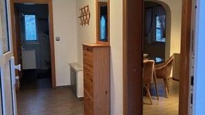 A hallway with a wooden dresser, a mirror, and a dining area with chairs. - Villa nikki, ideal base in croatia, 5o meters from the lake (Bilice)