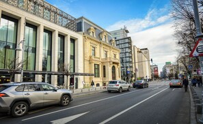 Eine Straße mit Autos, Fußgängern und Gebäuden.