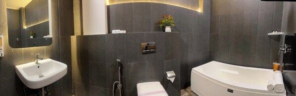 Ein modernes Badezimmer mit einem weißen Waschbecken, einer Badewanne und einer Dusche.
