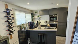 Eine moderne Küche mit Weinkühler, Kaffeemaschine und Kühlschrank.