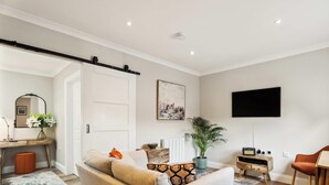 Ein modernes Wohnzimmer mit einer Couch, einem Couchtisch und einem an der Wand befestigten Fernseher.