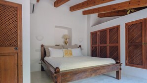 A bedroom with a wooden bed, white walls, and a tiled floor. - Can Sabuba (Deia)