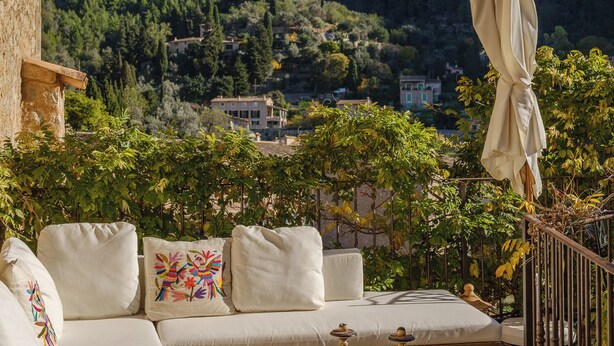A terrace with a sofa, a table with a tray, and an umbrella. - Can Sabuba (Deia)