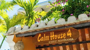 A wooden sign with 'Calm House 4' and an address.