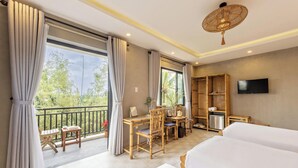 A hotel room with a balcony, a desk with chairs, a TV, and two beds. - Calm House 4 Hoi An (Thanh pho Hoi An)
